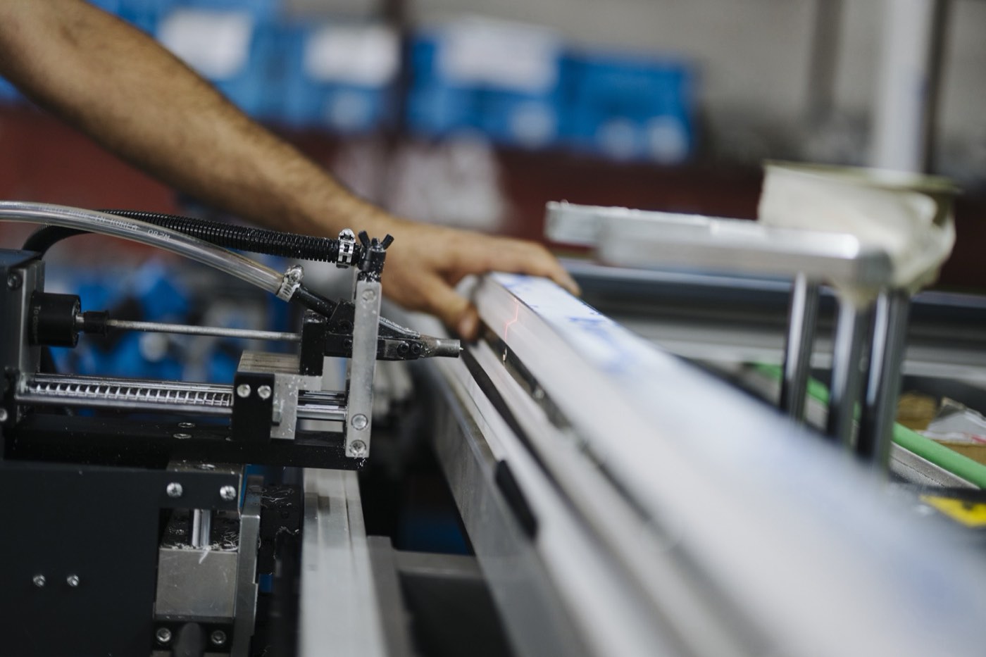 A worker operates machinery on a factory line